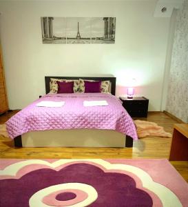 GhimbavAndreea Residence的一间卧室配有一张带粉色毯子的大床