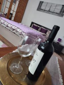 GhimbavAndreea Residence的一瓶葡萄酒和一张桌子上的一杯