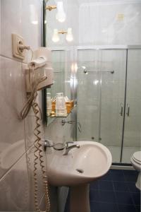 圣玛尔塔迪佩纳吉昂Hotel Oasis的一间带水槽和淋浴的浴室以及一部电话