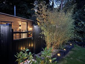 大雅茅斯Charming 1-Bed Lodge in woodland setting的院子里的栅栏,上面有灯