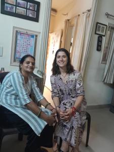 新德里Bhagvati BnB Homestay Apt的两个女人站在一个房间里,彼此相邻