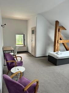 SęzinkoFolwark Matecznik - Dworek的一间设有紫色椅子和一张床的房间