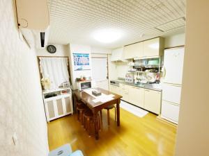 德岛Reinahill - Vacation STAY 67181v的厨房配有白色橱柜和木桌