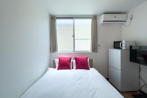 东京Elegant House的一间卧室配有一张带两个粉红色枕头的床