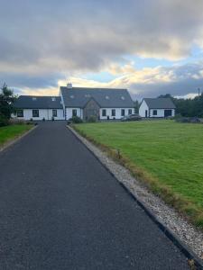 戈尔韦Connemara Ocean Escape的一条通往白色大房子的道路