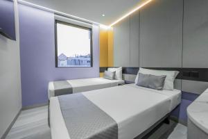 新加坡Hotel 81 Palace - NEWLY RENOVATED的带窗户的客房内的两张床