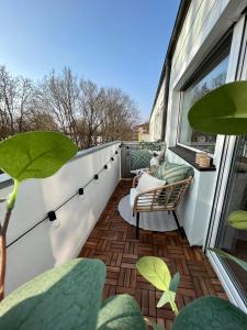 因戈尔施塔特Stilvolle 3-Zimmer Wohnung in Ingolstadt mit Balkon und guter Autobahnanbindung的大楼内的阳台配有椅子和植物
