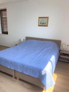 杜布罗夫尼克Dalmatins MillionDollar sea view的一间卧室配有一张带蓝色毯子的床