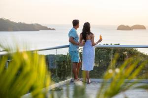 普拉亚埃尔莫萨Villas Sol Beach Resort - All Inclusive的一对夫妇站在一个眺望着大海的阳台