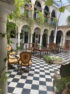 科尔多瓦Hostal Palacio del Corregidor的庭院的 ⁇ 板上设有桌椅