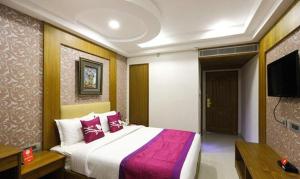 钦奈FabHotel Prime The Vijay Park的一间卧室配有一张大床和一台平面电视