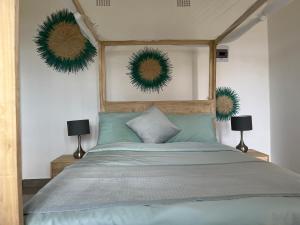 Nkhata BayNdau Lodge的卧室配有一张挂在墙上的绿色花圈床。