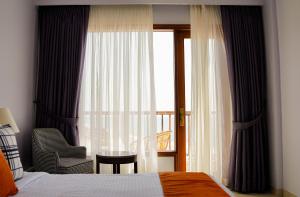 卡拉奇Destination Beach Hotel by Dreamworld的一间卧室配有一张床和一个带椅子的窗户