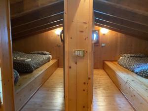 安达洛CHALET JOEN ski & bike Andalo的木墙客房的两张双层床