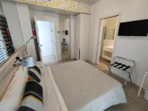 切萨雷奥港此处酒店的一间卧室配有一张床和一台电视