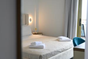 卡斯特罗西基亚Ninos Grand Beach Resort的一间卧室配有一张床,上面有两条毛巾