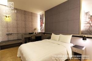 台中市Unique Hotel 黃埔75旅店 的卧室配有一张白色大床和一张书桌