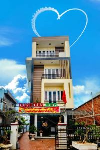 惹岛Thanh Tran Guesthouse Lý Sơn的上面有一颗心形云的建筑物
