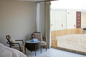 乌姆赛义德Al-Rahal Desert Camp的卧室配有一张床和一张桌子及椅子