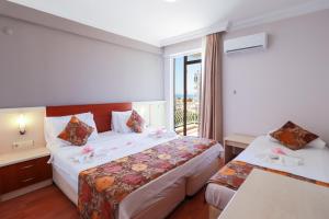 安塔利亚拉拉迪恩克酒店的酒店客房设有两张床和窗户。