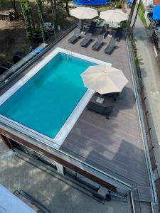 乌雷基Ritsa Resort的享有带遮阳伞的游泳池的顶部景致