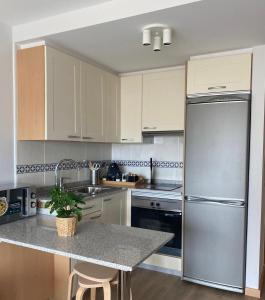 塞代拉Apartamento con vistas al mar Urb Puerto Azul B3的厨房配有白色橱柜和不锈钢冰箱