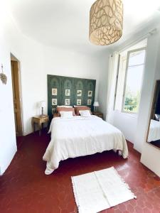旺斯Le Jardin D'Elma的卧室设有一张白色大床和一扇窗户。