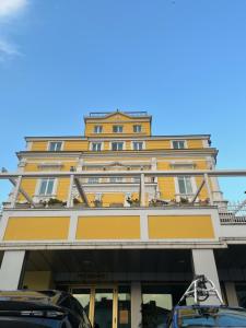 鲁塞安娜宫酒店的一座黄色的建筑,前面有汽车停放