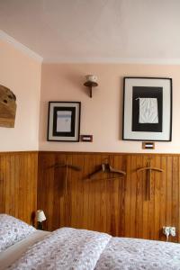辛特拉辛特拉小型旅馆的卧室配有一张床,墙上挂有两张照片
