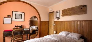 辛特拉辛特拉小型旅馆的一间卧室配有一张床、一张书桌和一面镜子
