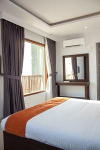 卡拉奇Destination Beach Hotel by Dreamworld的一间卧室设有一张床、一个窗口和一面镜子