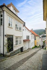 卑尔根Beautiful townhouse super Central in Bergen - 4 bedrooms 8 guests的白色建筑城镇中的鹅卵石街道