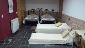 洛里加纳思散塔酒店的一间设有四张床铺和白色床单的客房