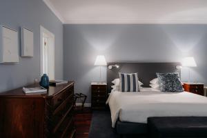 丰沙尔Quinta São Gonçalo的一间卧室配有一张大床、梳妆台和灯具。