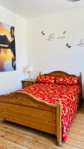 巴特施瓦尔陶gemütliche Wohnung的一间卧室配有一张带红色床罩的木床