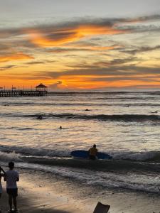 万查科Totora Surf Hostel的一群人,在日落时站在海滩上