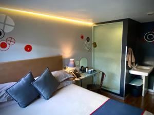 约翰内斯堡班尼斯特酒店的一间卧室配有一张带蓝色枕头的床和一张书桌