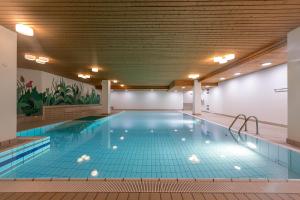 圣莫里茨Esclusivo bilocale centralissimo的大型室内游泳池,铺有蓝色瓷砖地板