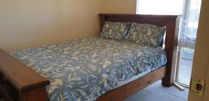 Little RiverStandard Queen size bedroom的一张带蓝白色床罩的木架床
