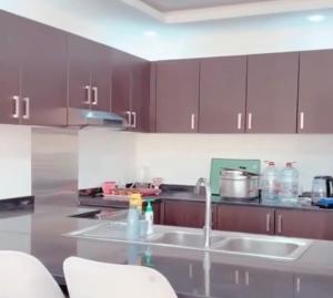 豪尔费坎Al Sharq Holiday Home的厨房配有棕色橱柜和台面