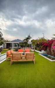 豪尔费坎Al Sharq Holiday Home的绿色草坪上带长凳的花园