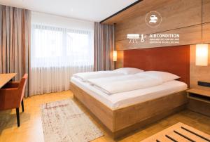 阿勒斯贝格Hotel SCHNEIDER的一间卧室配有一张大床和木制床头板