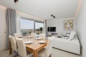 马拉加Modern holiday apartment with incredible sea views in La Cala de Mijas的一间带桌子和白色沙发的用餐室