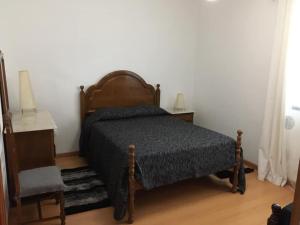 TerreirosCasa do Carroça的卧室配有1张床、1张桌子和1把椅子