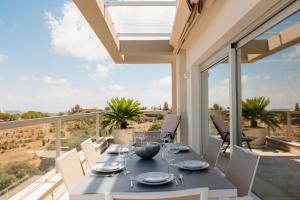 马拉加Modern holiday apartment with incredible sea views in La Cala de Mijas的房屋阳台上的餐桌和椅子