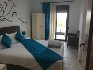 克里皮吉Petra Mare的一间卧室配有一张带蓝色床单的床和一扇窗户。