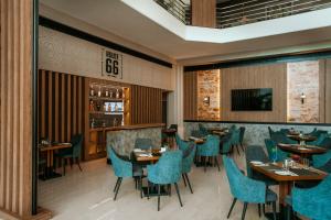 帕福斯St George Beach Hotel & Spa Resort的餐厅设有木桌和蓝色椅子