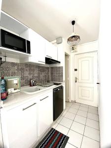 莱特鲁瓦西莱Apt T1,bien situé Anse Mitan Trois Ilets的白色的厨房配有水槽和微波炉
