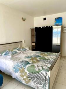 莱特鲁瓦西莱Apt T1,bien situé Anse Mitan Trois Ilets的一间卧室配有一张带花卉棉被的大床