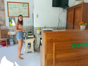 八丹拜Jepun Inn的站在厨房准备食物的妇女